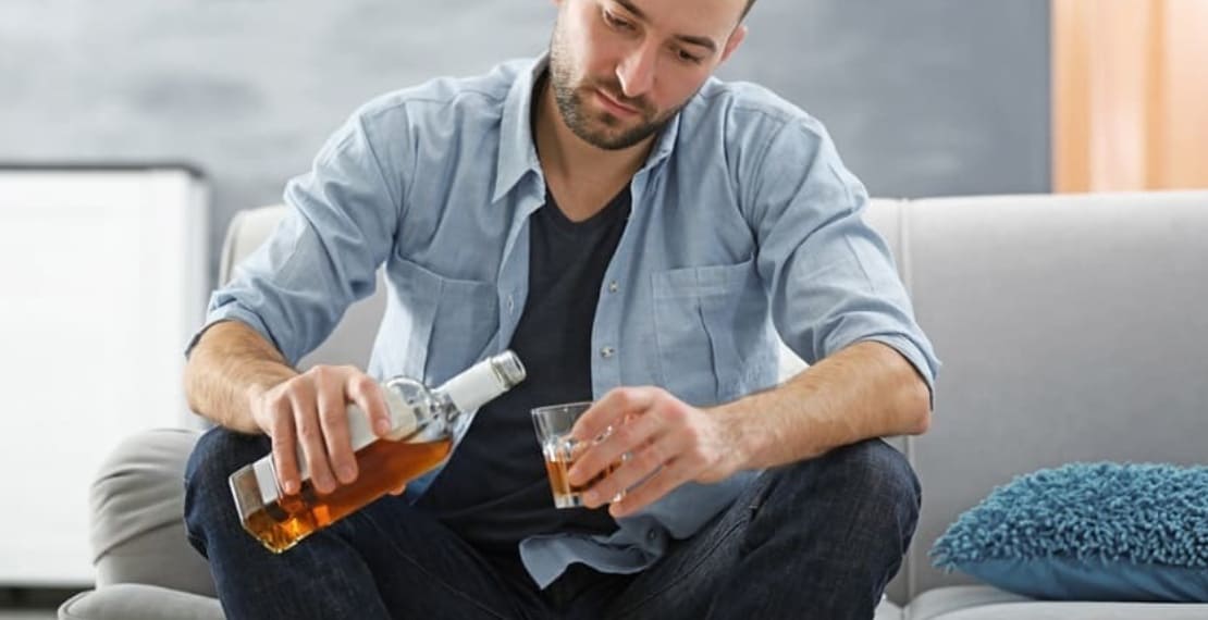 Мужчина наливает алкоголь в стакан